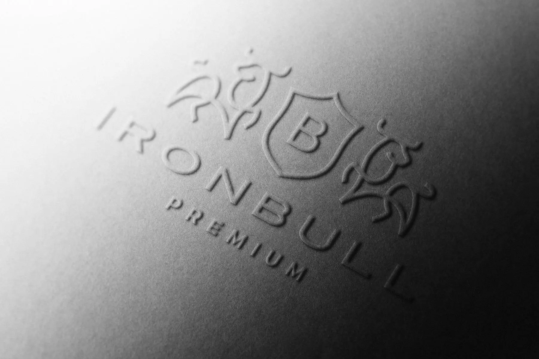 Detalle de un logotipo en relieve sobre una superficie gris.