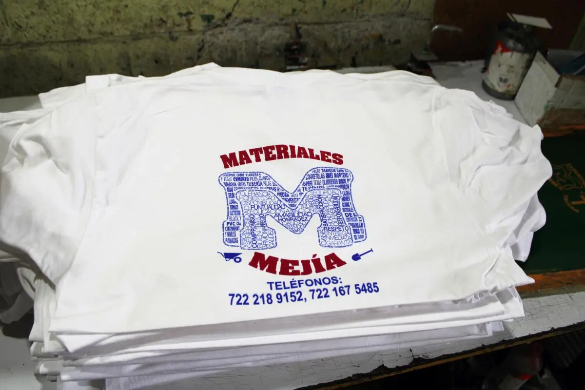 Playeras blancas con diseño impreso en azul y rojo.