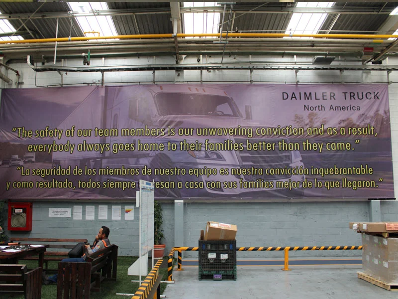 Lona de gran formato con un mensaje de seguridad colocada en una nave industrial.